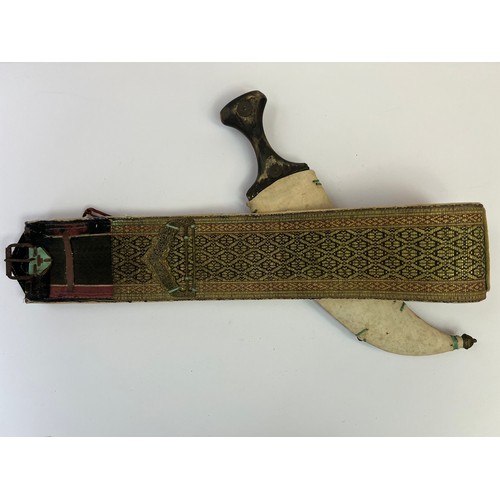 49 - A BRASS JAMBIYA DAGGER WITH A BELT, POSSIBLY OMAN, EARLY 20TH CENTURY

With a double-edged curved st... 