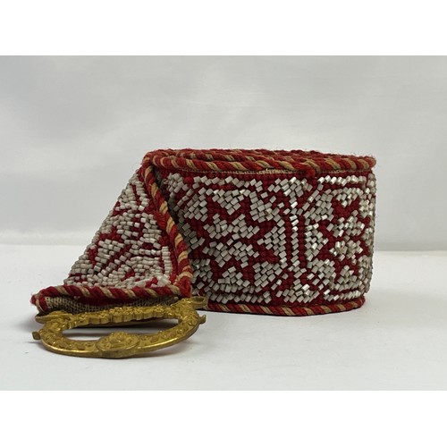 50 - A CRAFTMANSHIP BEADWORK BELT WITH BUCKLE

Mounted on a cream textile, adorned with successive eight ... 