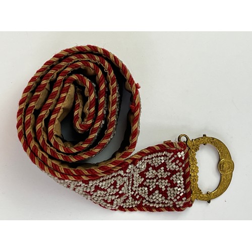 50 - A CRAFTMANSHIP BEADWORK BELT WITH BUCKLE

Mounted on a cream textile, adorned with successive eight ... 