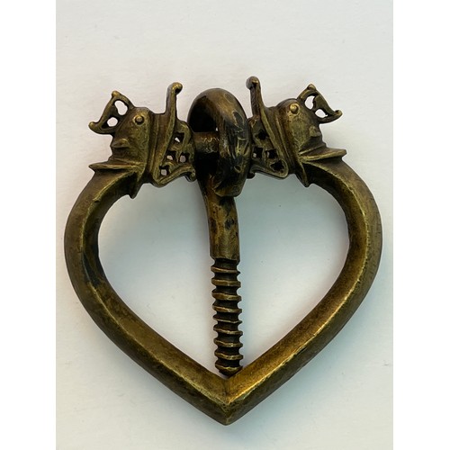 75 - A BRASS DOOR KNOCKER
Of heart shape, modelled with stylised dragon head terminals676 gr
11 cm dia