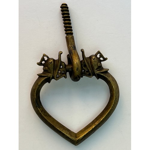 75 - A BRASS DOOR KNOCKER
Of heart shape, modelled with stylised dragon head terminals676 gr
11 cm dia