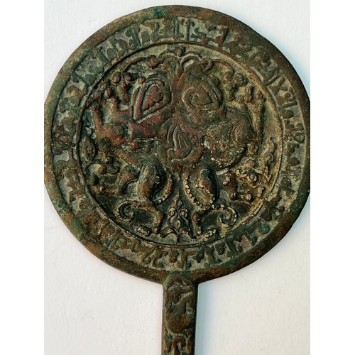 77 - A SELJUK 
STYLE CAST BRONZE MIRROR WITH SPHINXES, IRAN OR ANATOLIA,
Of circular shape with a thin st... 