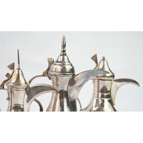 80 - A SET OF FOUR IRAQ SILVER DALLAH COFFEE POTS   Of traditional shapes, silver coffee pots with long s... 