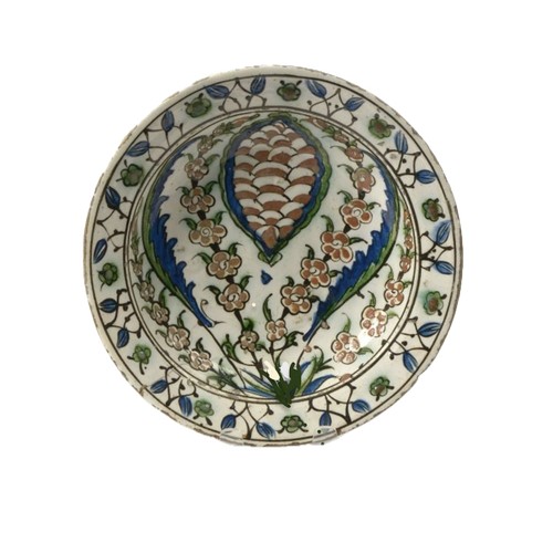 92 - AN IZNIK POTTERY DISH, 17th CENTURY, OTTOMAN TURKEY   With sloping rim on short foot, the white inte... 