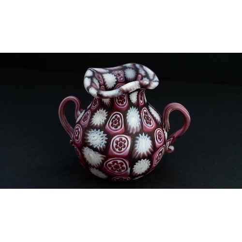 113 - A FRATELLI TOSO MURANO MILLEFIORI TINY VASE
Of bulbous form, resting on a flat base, two S-scroll ha... 