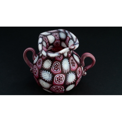 113 - A FRATELLI TOSO MURANO MILLEFIORI TINY VASE
Of bulbous form, resting on a flat base, two S-scroll ha... 