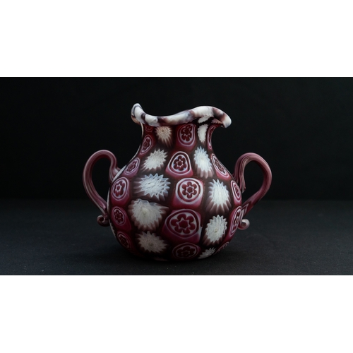 113 - A FRATELLI TOSO MURANO MILLEFIORI TINY VASE
Of bulbous form, resting on a flat base, two S-scroll ha... 