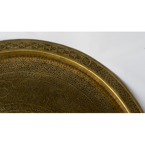 75 - A LARGE BRASS TRAY
Of large circular form, resting on a flat, plain base, rising to a flattened, eve... 