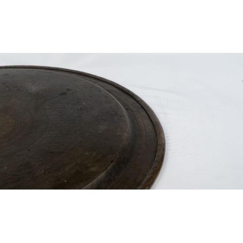 76 - A SILVER-INLAID BRASS TRAY
Of large circular form, resting on a flat, plain base, rising to a flatte... 