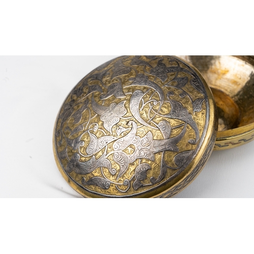 78 - A ROUND SILVER-INLAID BRASS BOX
Of rounded form resting on a plain surface, with a pull-off lid, the... 