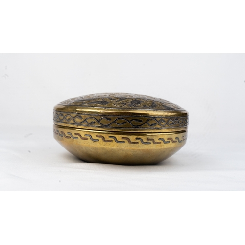 78 - A ROUND SILVER-INLAID BRASS BOX
Of rounded form resting on a plain surface, with a pull-off lid, the... 