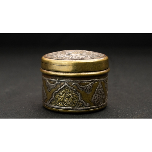 79 - A SILVER-INLAID BRASS SNUFF BOX,
Of circular form with a domed pull off lid, the exterior with brass... 