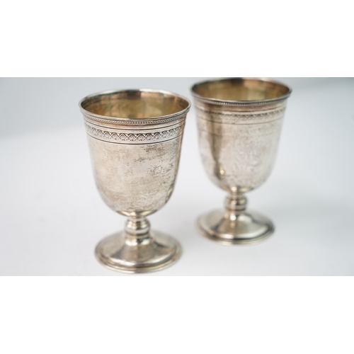 12 - A PAIR OF SILVER CUPS Of rounded circular form, rising from a splayed foot, the body with a palmette... 