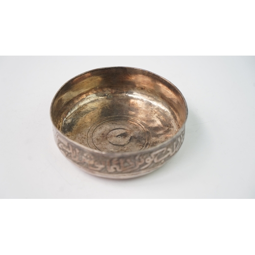 5 - A SILVER BOWL WITH ARABIC INSCRIPTION Of rounded form, resting on a flat base, the exterior decorate... 