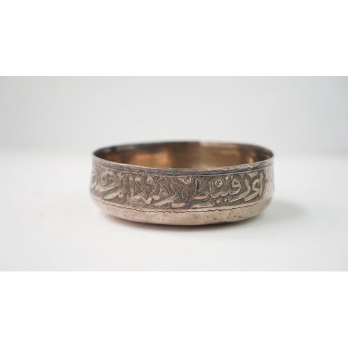 5 - A SILVER BOWL WITH ARABIC INSCRIPTION Of rounded form, resting on a flat base, the exterior decorate... 