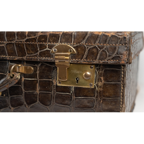 3 - AN EARLY 
20TH CENTURY DARK BROWN CROCODILE LEATHER SUITCASE.Of rectangular form, a travel case feat... 