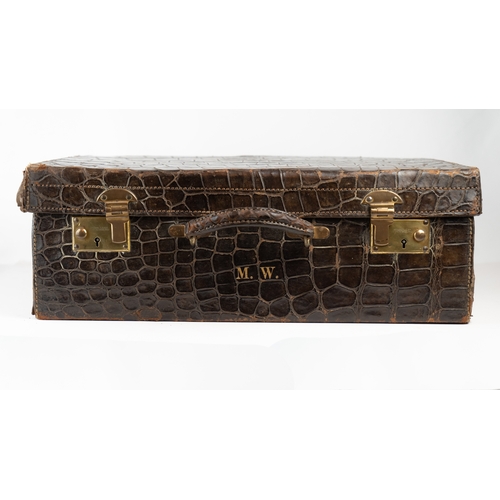 3 - AN EARLY 
20TH CENTURY DARK BROWN CROCODILE LEATHER SUITCASE.Of rectangular form, a travel case feat... 