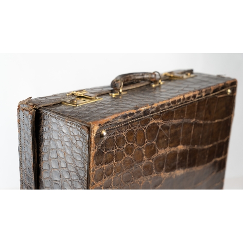 3 - AN EARLY 
20TH CENTURY DARK BROWN CROCODILE LEATHER SUITCASE.Of rectangular form, a travel case feat... 