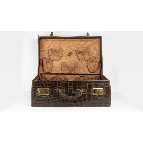 3 - AN EARLY 
20TH CENTURY DARK BROWN CROCODILE LEATHER SUITCASE.Of rectangular form, a travel case feat... 