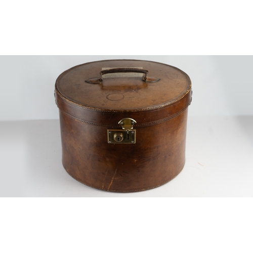 11 - A VINTAGE LEATHER HAT BOX, mid 20th Century.Of cylindrical form, a leather hat box in rich brown hue... 