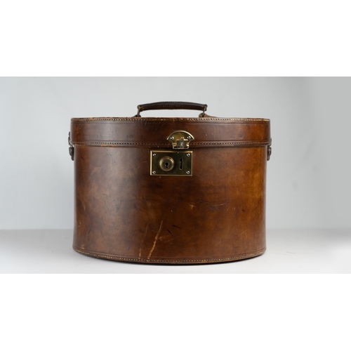 11 - A VINTAGE LEATHER HAT BOX, mid 20th Century.Of cylindrical form, a leather hat box in rich brown hue... 