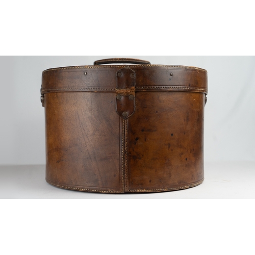 11 - A VINTAGE LEATHER HAT BOX, mid 20th Century.Of cylindrical form, a leather hat box in rich brown hue... 