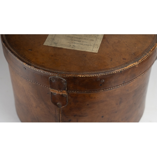 11 - A VINTAGE LEATHER HAT BOX, mid 20th Century.Of cylindrical form, a leather hat box in rich brown hue... 