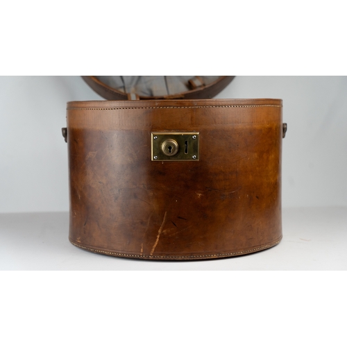 11 - A VINTAGE LEATHER HAT BOX, mid 20th Century.Of cylindrical form, a leather hat box in rich brown hue... 