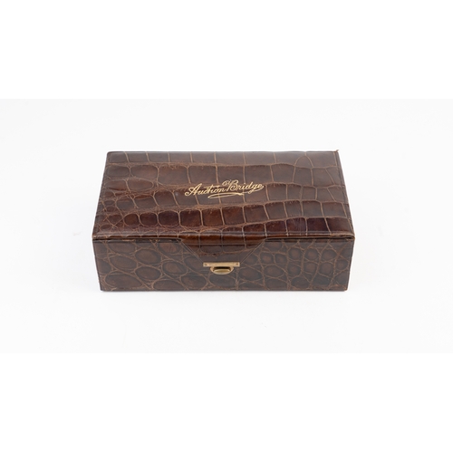 46 - A CROCODILE LEATHER BRIDGE CASE,
EARLY 20TH CENTURY
Of rectangular form, the brown crocodile leather... 