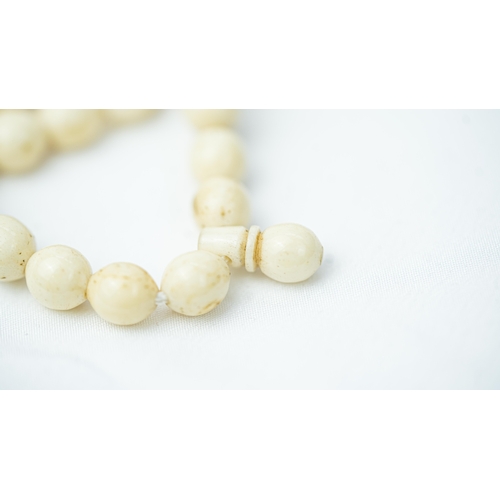 92 - A MORS TOOTH PRAYER BEADS

The tasbih strung  with 99 bone spherical  beads, flat stops, narrowing a... 