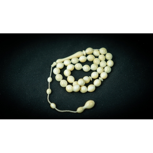 95 - A BONE PRAYER BEADS

The tasbih strung with 33 bone spherical beads, flat stops, narrowing and elong... 