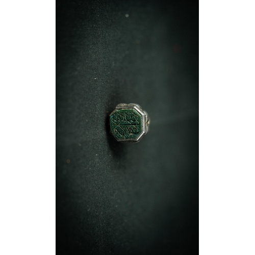 99 - A SILVER FRAMED ARABIC INSCRIPTION CARVED SPINACH GREEN JADE SEAL
Of octagon shape, the jade seal fe... 