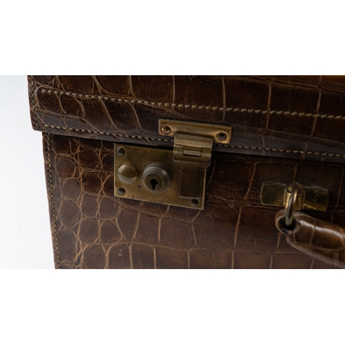 110 - AN EDWARDIAN ALLIGATOR SUITCASE,

Of rectangular shape, crafted in a crocodile-patterned leather, fe... 