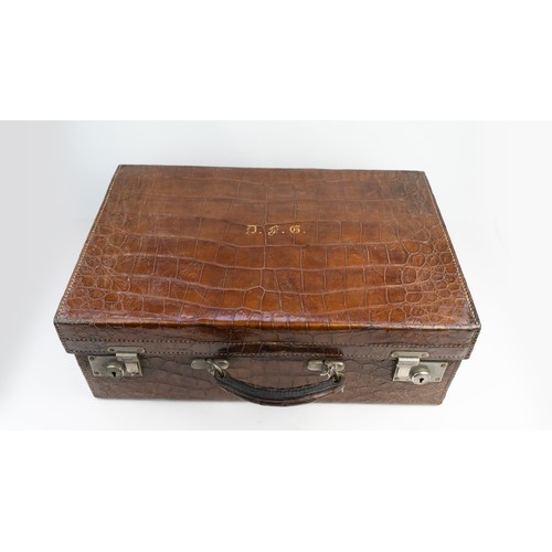 109 - A CROCODILE LEATHER TRAVEL SUITCASE

Of rectangular form, a crocodile travel suitcase in brown hues,... 