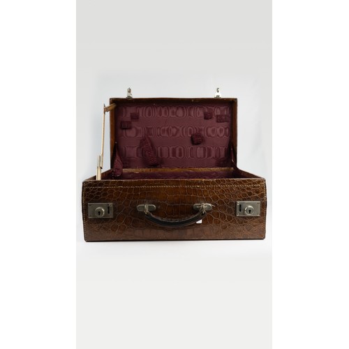 109 - A CROCODILE LEATHER TRAVEL SUITCASE

Of rectangular form, a crocodile travel suitcase in brown hues,... 