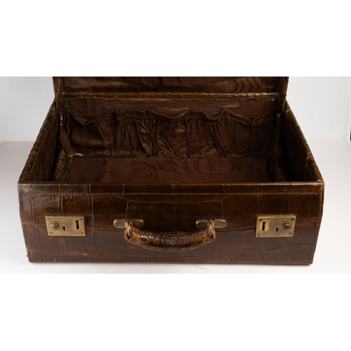 112 - A BROWN CROCODILE SUITCASE
Of rectangular form, fashioned in dark brown crocodile embossed leather, ... 