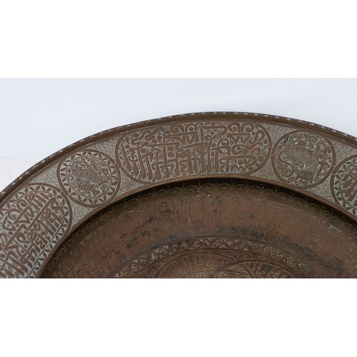 103 - A LARGE AND FINE BRASS DISH WITH ENGRAVED DECORATION, PERSIAN OR MAMLUK
Of circular form with a broa... 