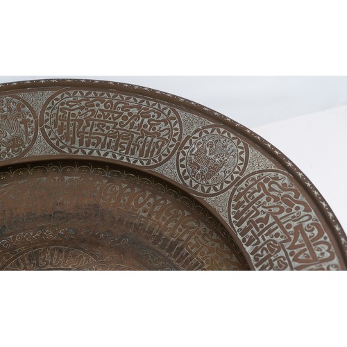 103 - A LARGE AND FINE BRASS DISH WITH ENGRAVED DECORATION, PERSIAN OR MAMLUK
Of circular form with a broa... 