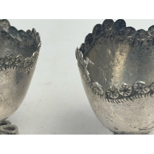 52 - THREE SILVER COFFEE CUPS, OTTOMAN EMPIRE

Each raised on a scalloped circular foot, the plain taperi... 