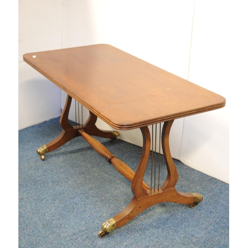 213 - Mahogany coffee table on lyre supports with turned stretcher, on four splayed legs with brass castor... 