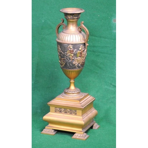 131 - Brass Two handled Urn with carved frieze on brass base