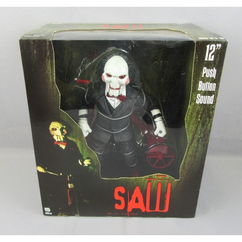 59 - NECA / REEL TOY 12” ‘SAW’ Billy the Puppet with Tricycle (Push Button Sound) in Unopened Near Mint P... 