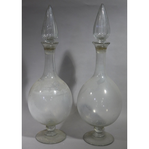 21 - A pair of Victorian apothecary's glass display bottles with faceted hollow spire stopper, baluster b... 