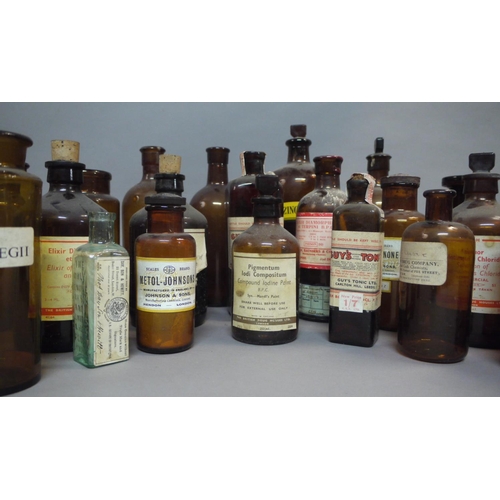 68 - A collection of brown glass pharmacy bottles and jars, including two sealed bottles of Guy's Tonic, ... 