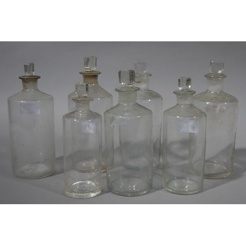 80 - A set of seven clear glass pharmacy bottles, cylindrical, with stoppers, various sizes, 23cm to 19cm... 