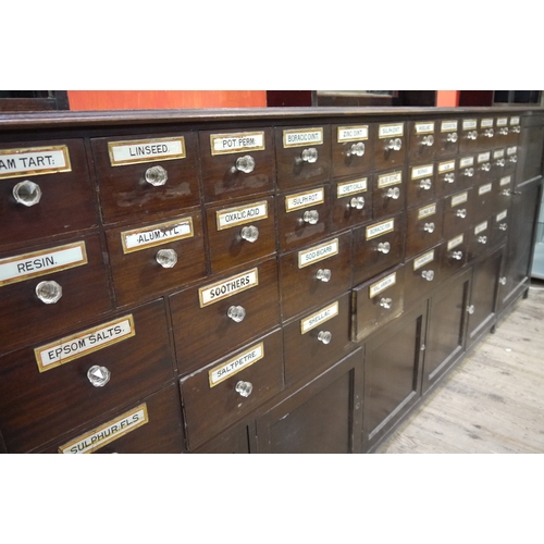 64 - A late 19th century mahogany pharmacy cabinet, having a moulded cornice above three sets of open she... 