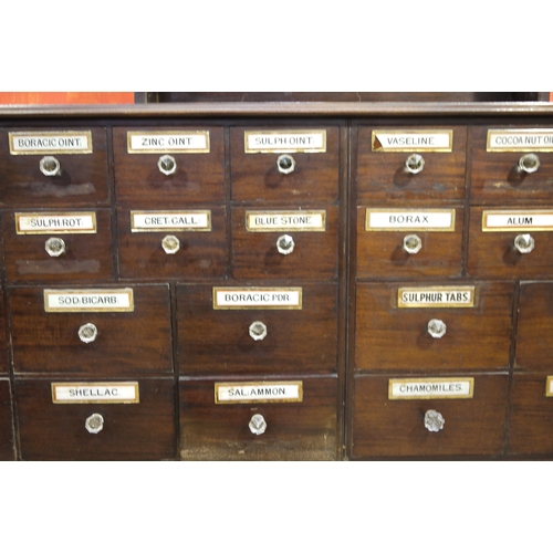 64 - A late 19th century mahogany pharmacy cabinet, having a moulded cornice above three sets of open she... 