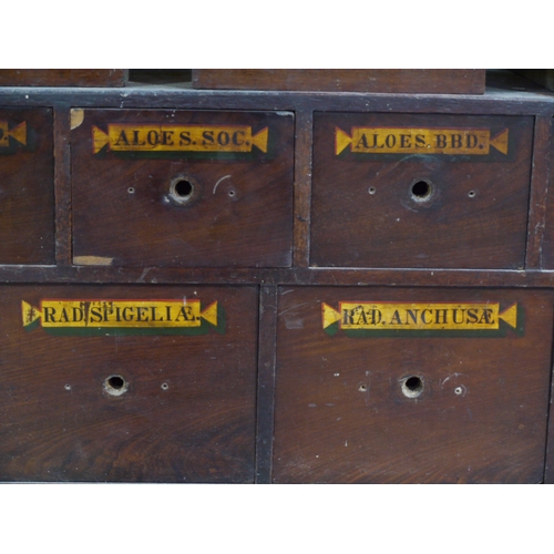 83 - A run of 54 graduated pharmacy drawers in three sections mahogany stained and lettered in black on g... 