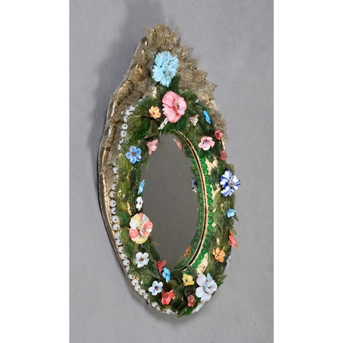 482 - AN ORNATE VENETIAN OVAL WALL MIRROR, the convex moulded ground applied with coloured glass flowers a... 