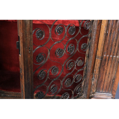 632 - AN ITALIAN WALNUT CUPBOARD, having a flared and dentil cornice above a deep frieze and two iron gril... 